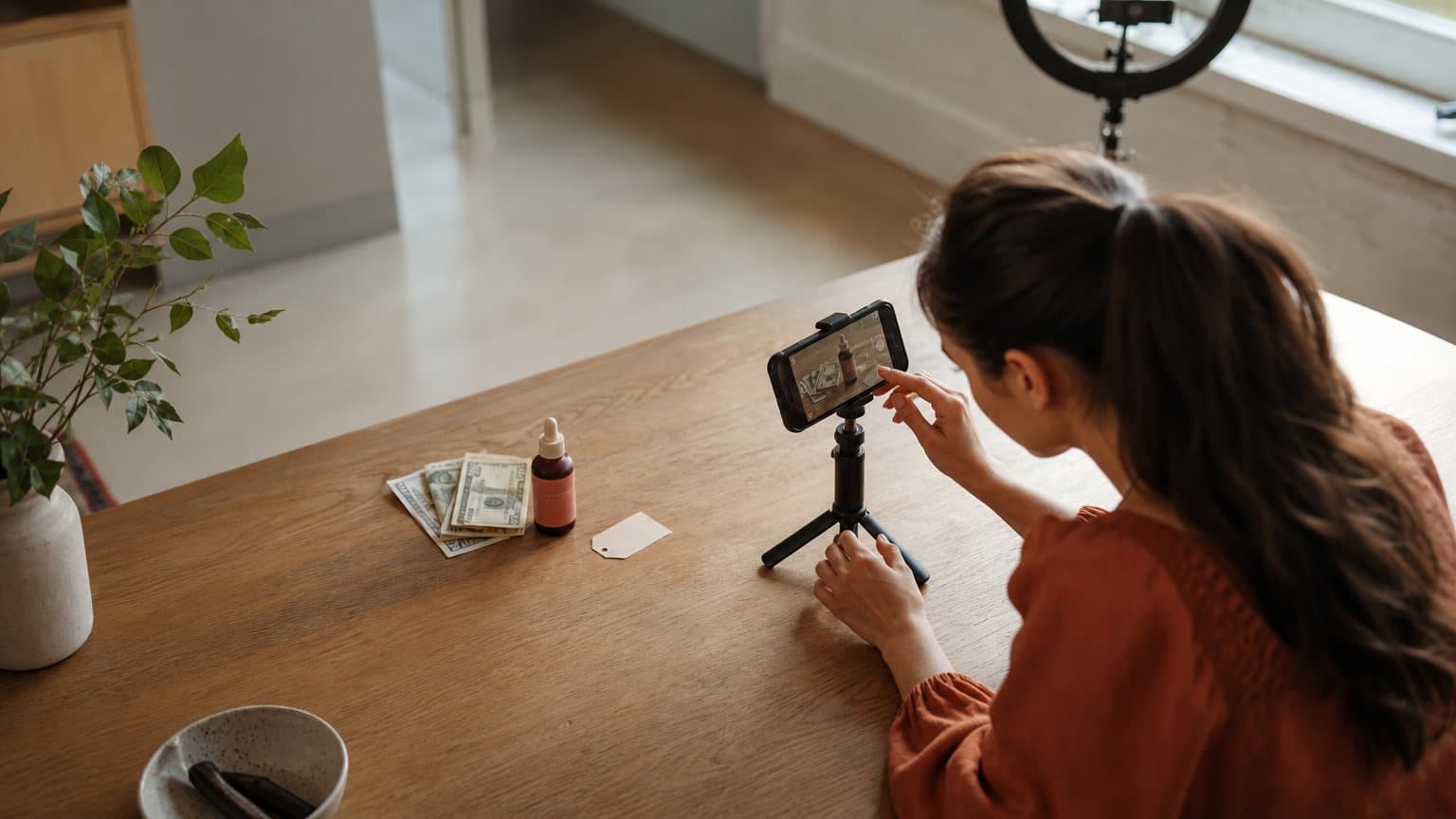 A real UGC creator filming a phone-shot product review at a kitchen table